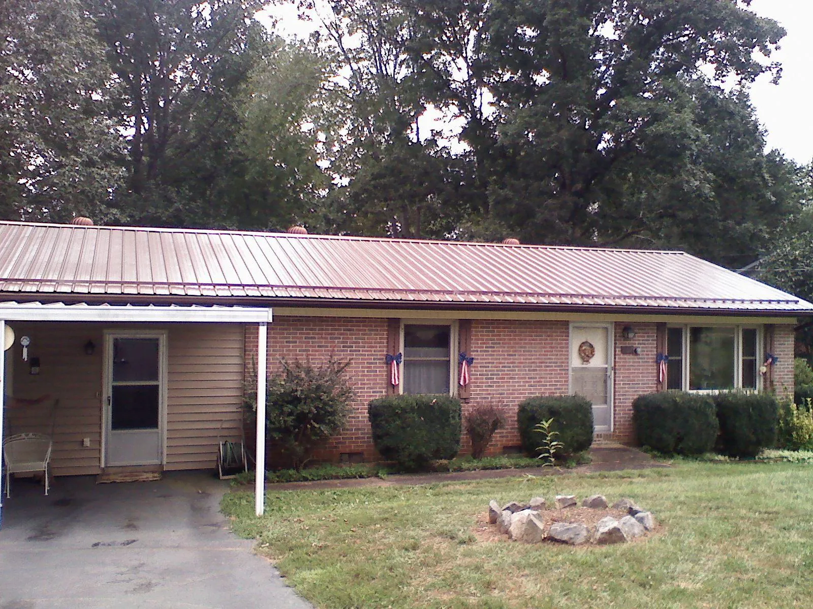 Bronze metal roof and carport on a brick ranch home — Roof Repair work by our crew in Warrenton